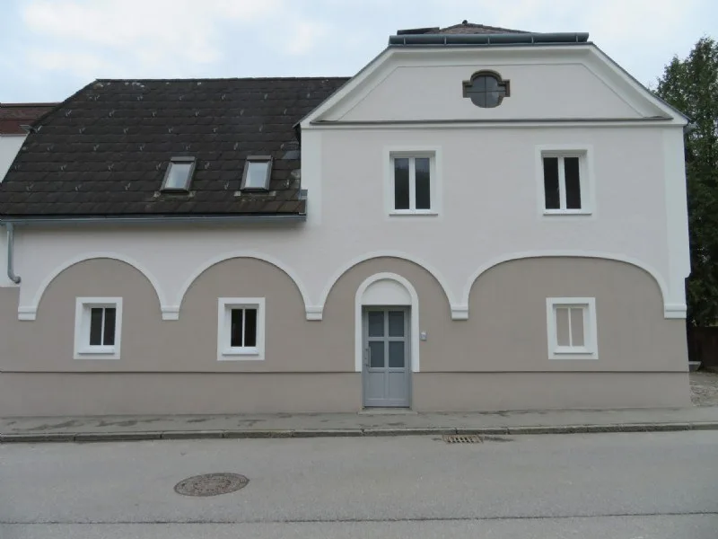 Zweifarbige Fassade mit Bogenfries an einem Altbau