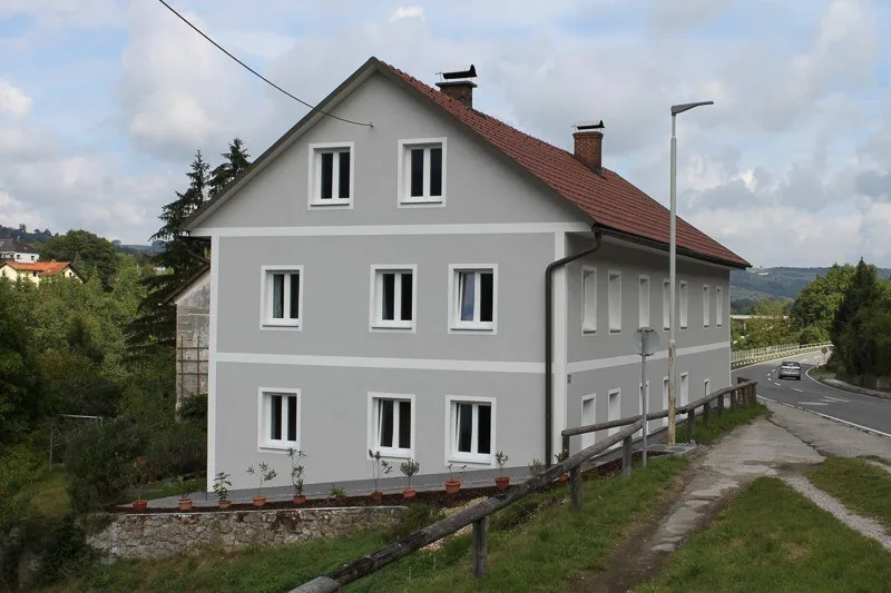 Dasselbe Haus mit neuer grauer Fassade und weißen Faschen