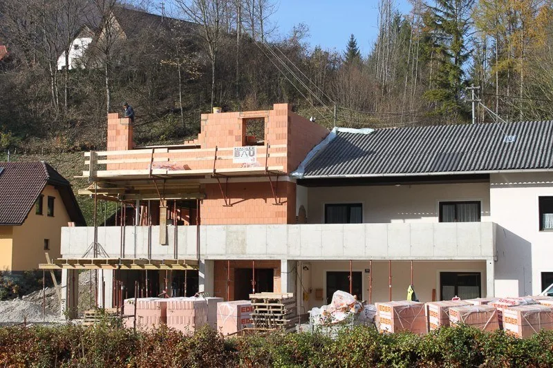 Aufstockung im Ziegelrohbau mit Bautafel von Nagler Bau